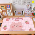 Cute pastel desktop setup with large strawberry bear mouse pad, stationery, and tablet display