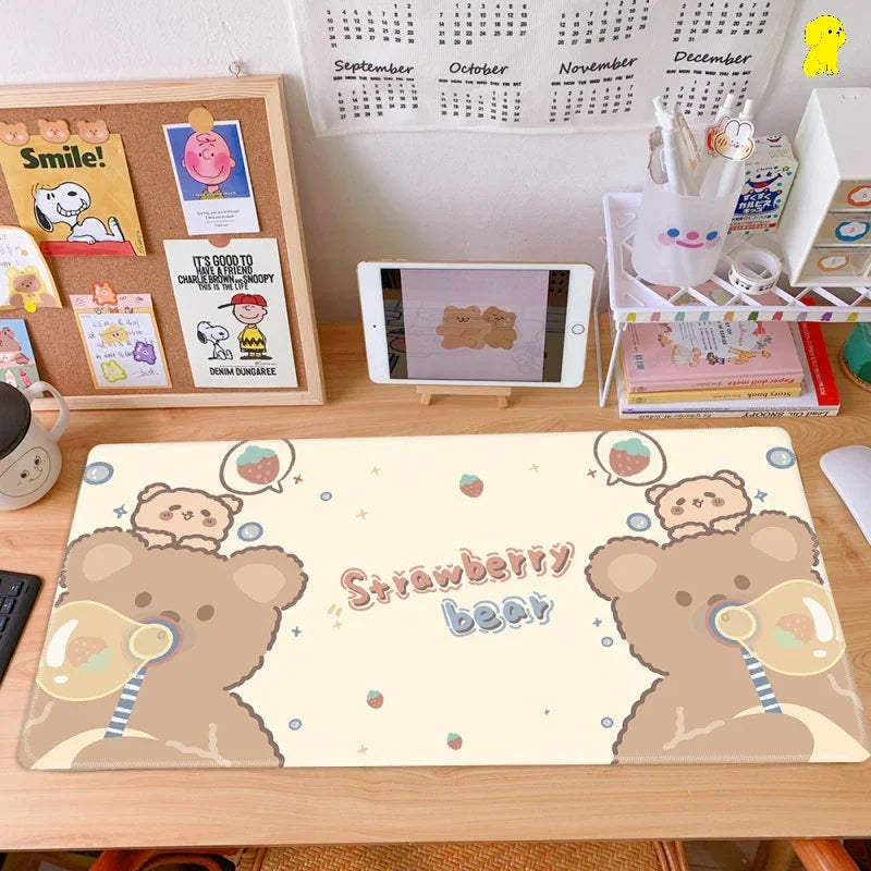 Cute pastel desk setup with Strawberry Bear cartoon mouse pad, calendar, tablet, and stationery.