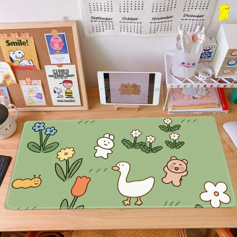 Cute cartoon animal desk mat on a tidy workspace with organized pens, books, and a tablet.