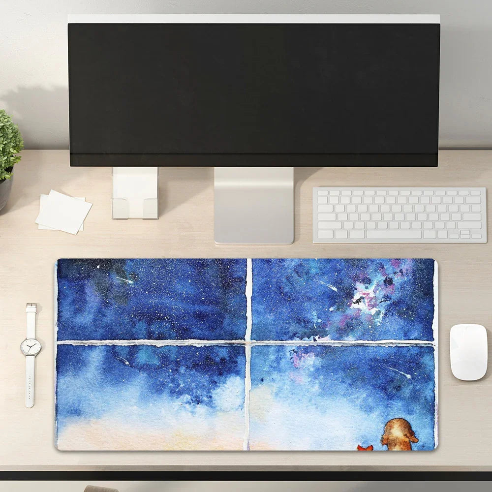 Modern workspace with large monitor, keyboard, and a colorful galaxy desk mat featuring a dog and cat.