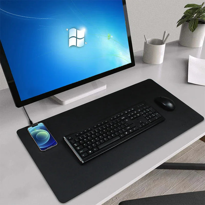 Modern ergonomic workspace with desktop monitor, keyboard, wireless charger desk pad, and mouse