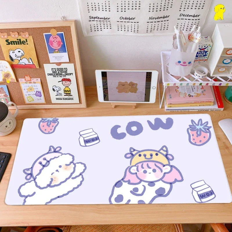 Cute cartoon cow desk mat on tidy workspace with tablet, stationery, calendar and corkboard