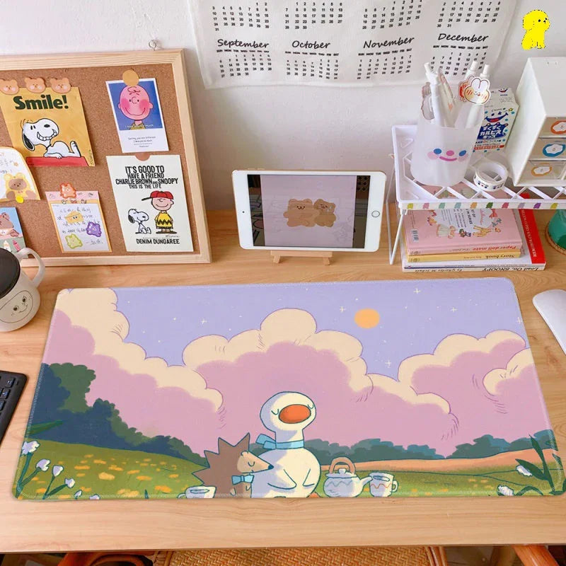 Cute pastel desk setup with a large cartoon mouse pad, iPad, organizer, and corkboard decor.