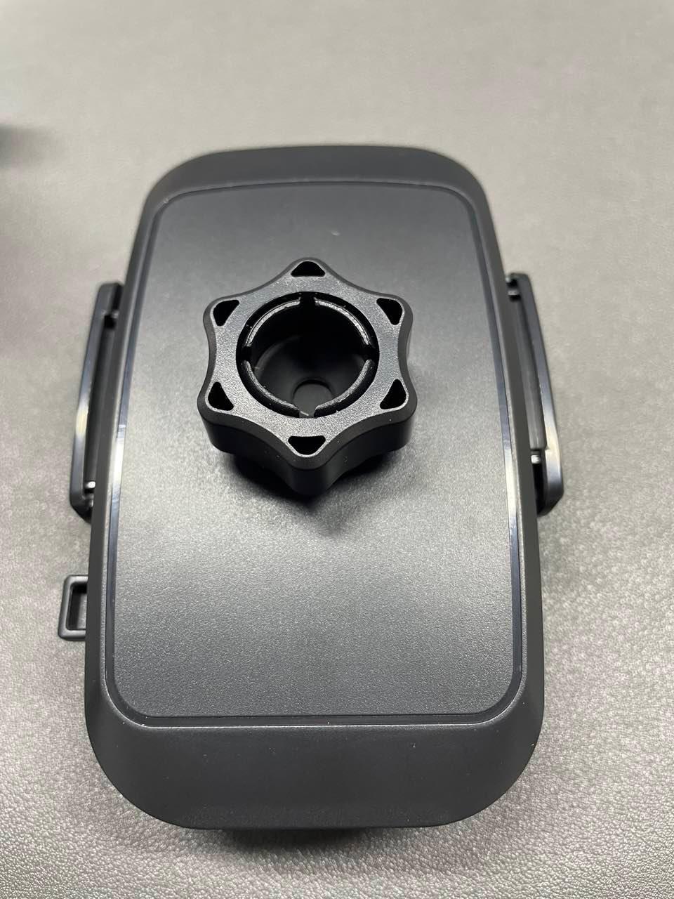 Black mounting bracket for studio lighting or broadcast equipment on gray surface